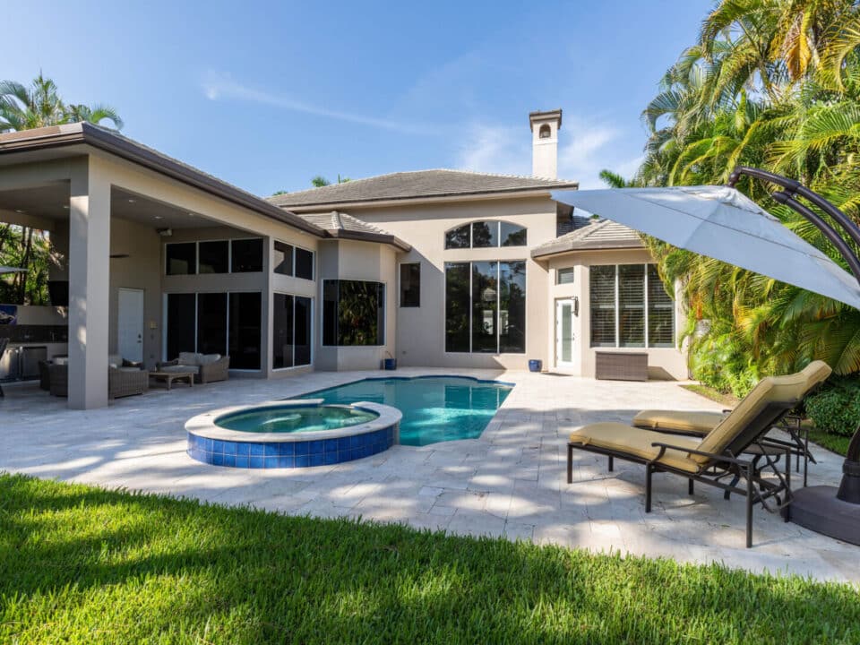 A cozy outdoor patio area with comfortable seating, a table, and decorative plants.