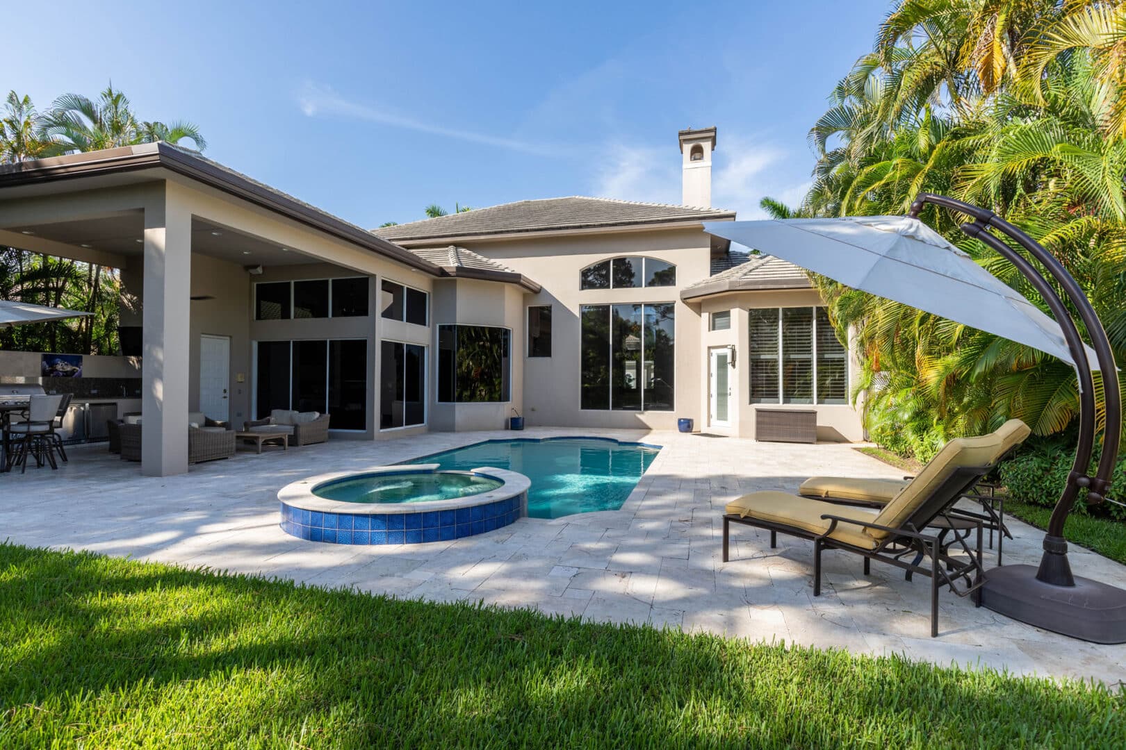 A cozy outdoor patio area with comfortable seating, a table, and decorative plants.